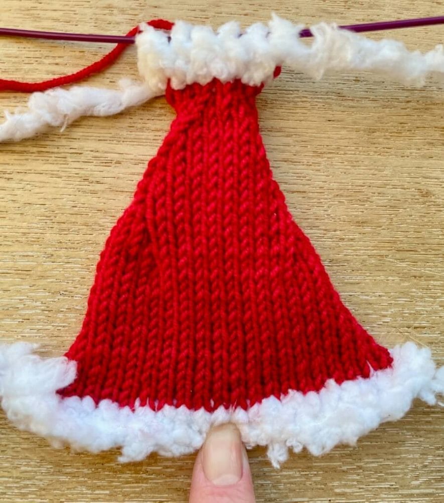 Finished flat knitted Santa hat piece