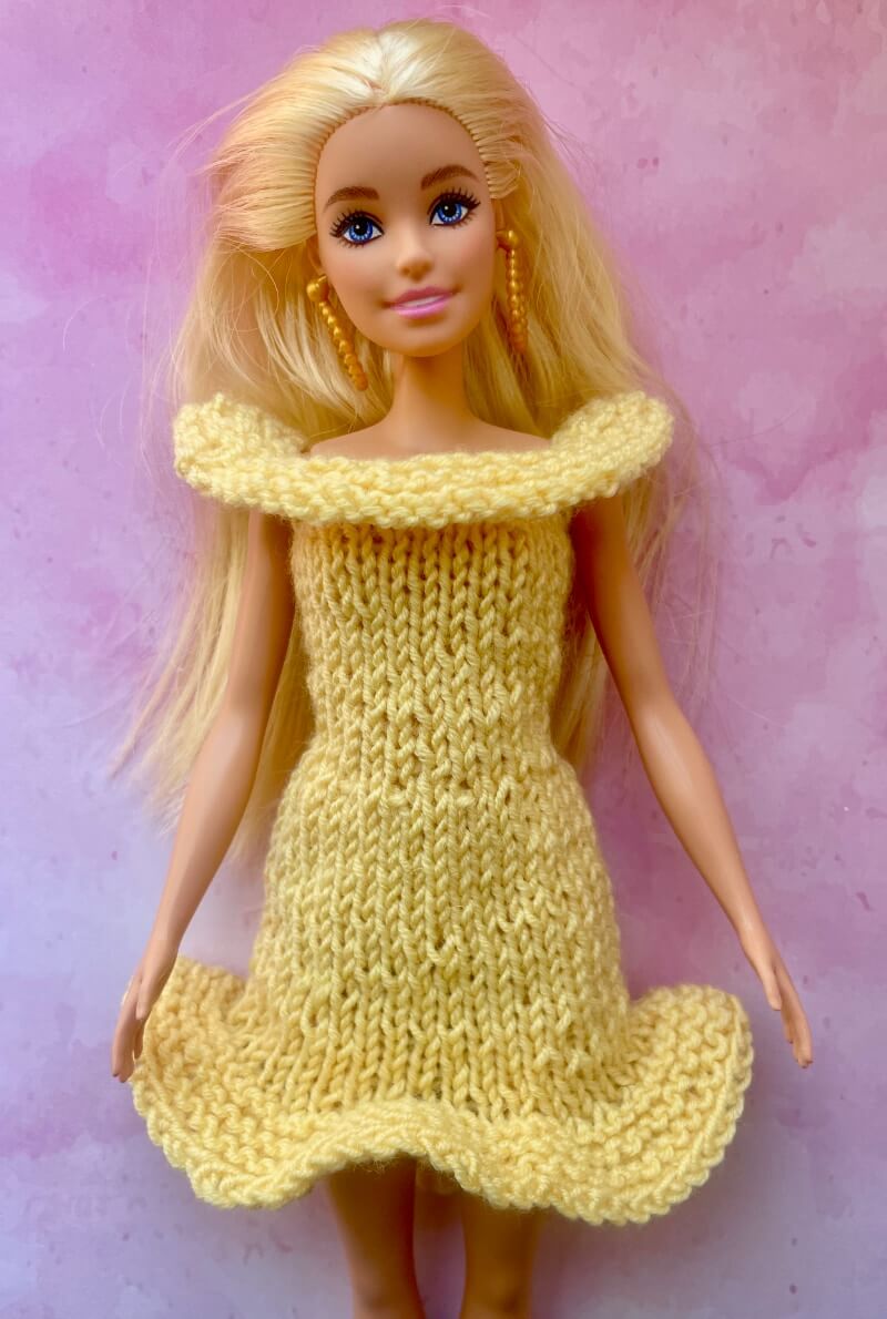 Barbie doll wearing yellow knitted dress with top and bottom ruffle