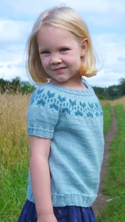 Young girl wearing Elena yoke t-shirt free knitting pattern by Berroco