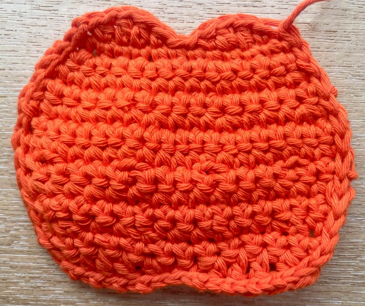 Crochet pumpkin after working slip stitches around 3 sides to neaten it