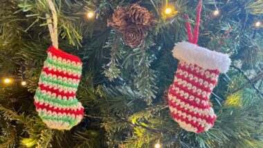 Striped crochet mini stockings hanging on Christmas tree