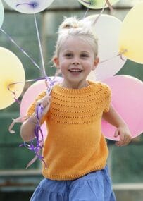 Girl wearing yellow Filcolana Gefion t-shirt knitting pattern and holding balloons