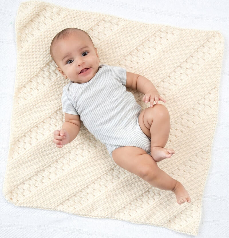 Free diagonal eyelets and garter stitch baby blanket knitting pattern from Lion Brand