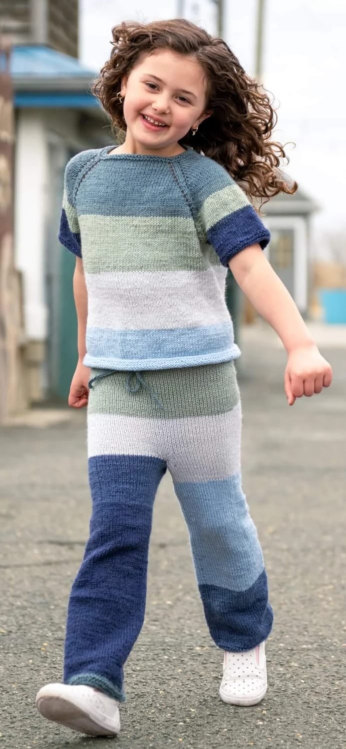 Girl wearing matching striped t-shirt and trousers knit with free Lion Brand pullover and pants set pattern