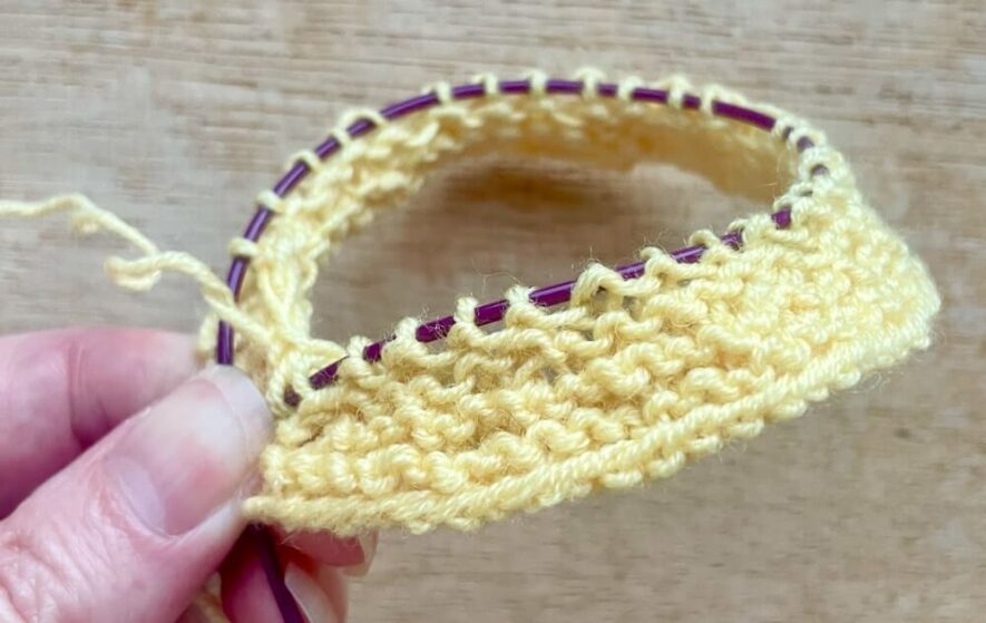 How your knitting looks after round 8 with the ruffle neck complete