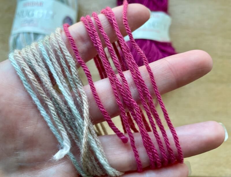 Close-ups of strands of Snuggly Crofter DK (left) vs Snuggly DK solids (right, cherry red)