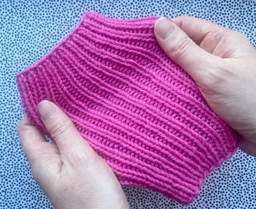 Ribbed mitt being stretched in hand